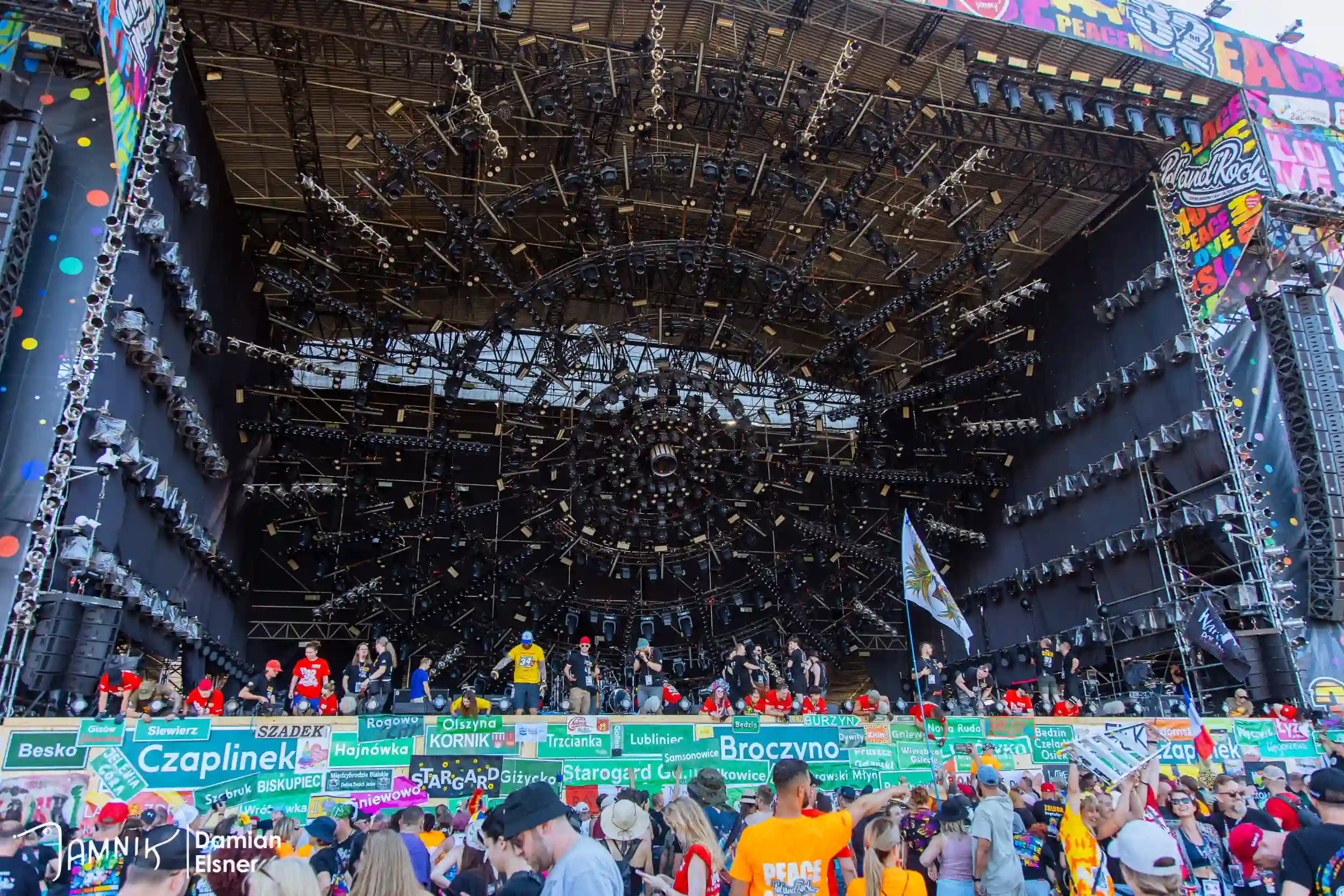 Festiwalowicze zgromadzeni pod sceną z flagami